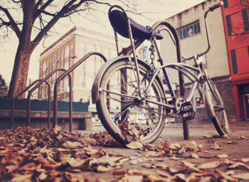 a bicycle chained up on an empty city street