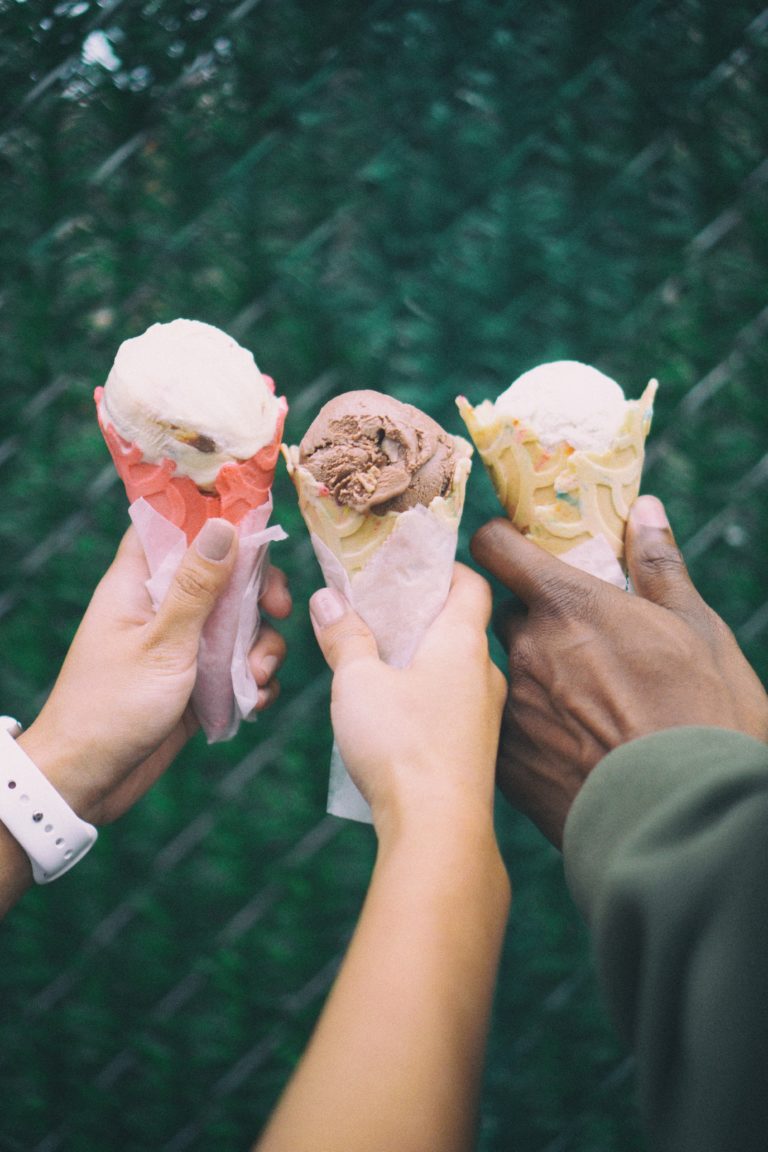 three people holding two different types of ice cream